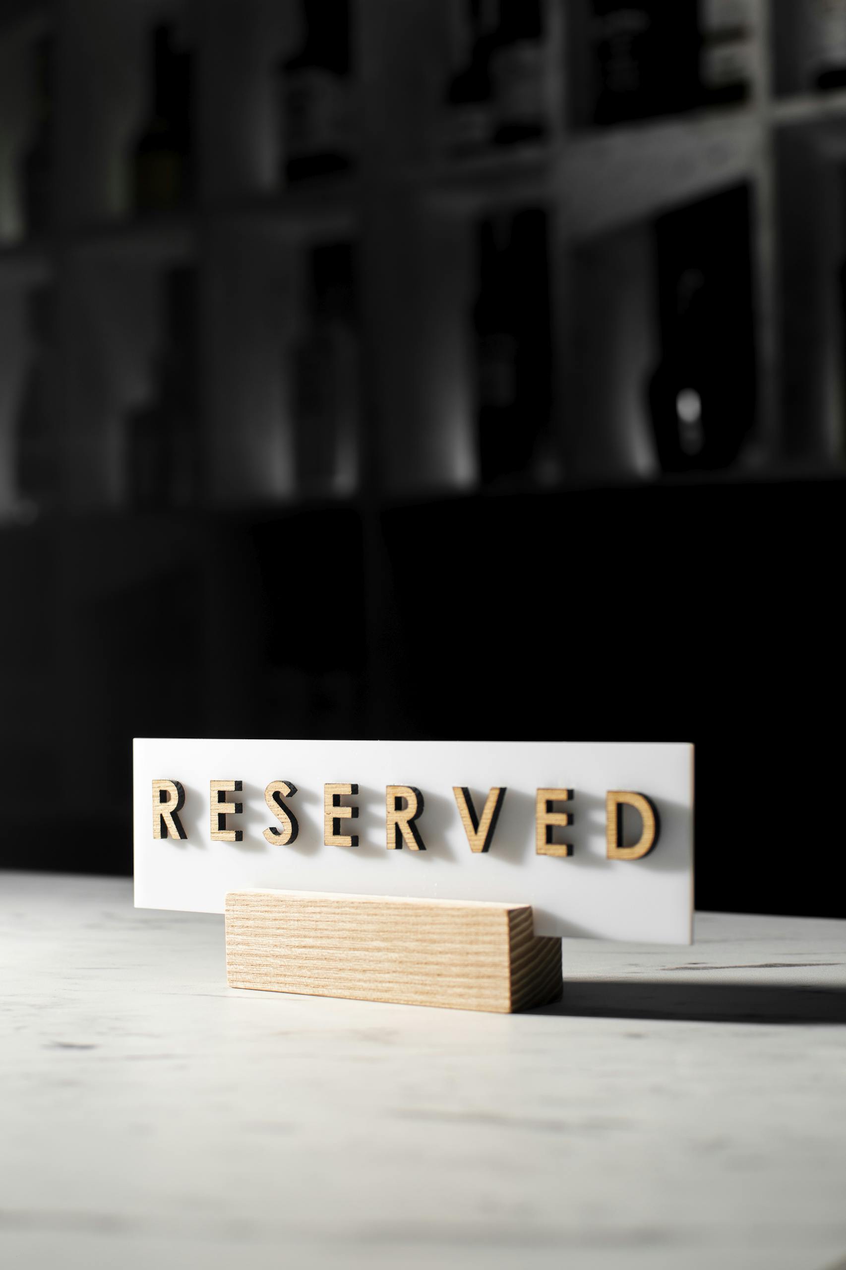 A 'Reserved' sign on a table in a stylish, dimly lit restaurant interior.