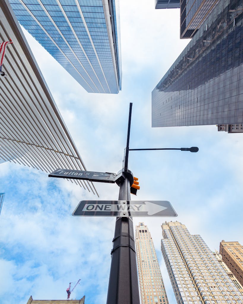 A vibrant upward view of skyscrapers from a street intersection in New York City.