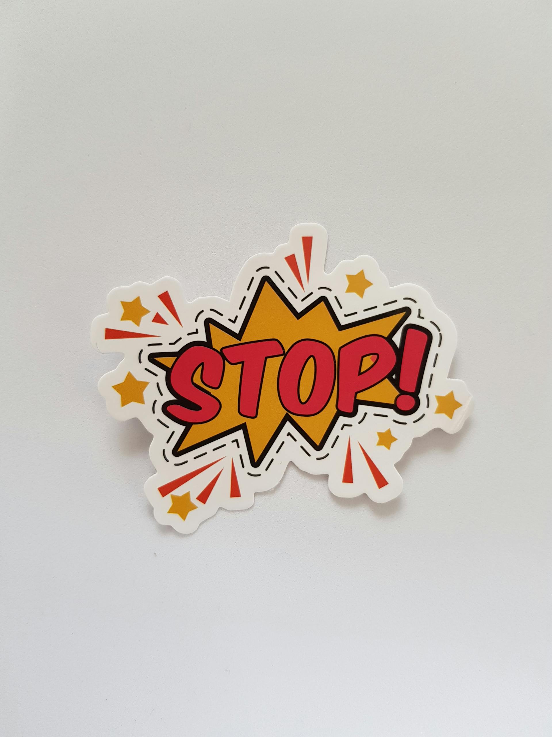 Bright and colorful sticker design featuring a comic-style 'Stop!' sign on a gray background.